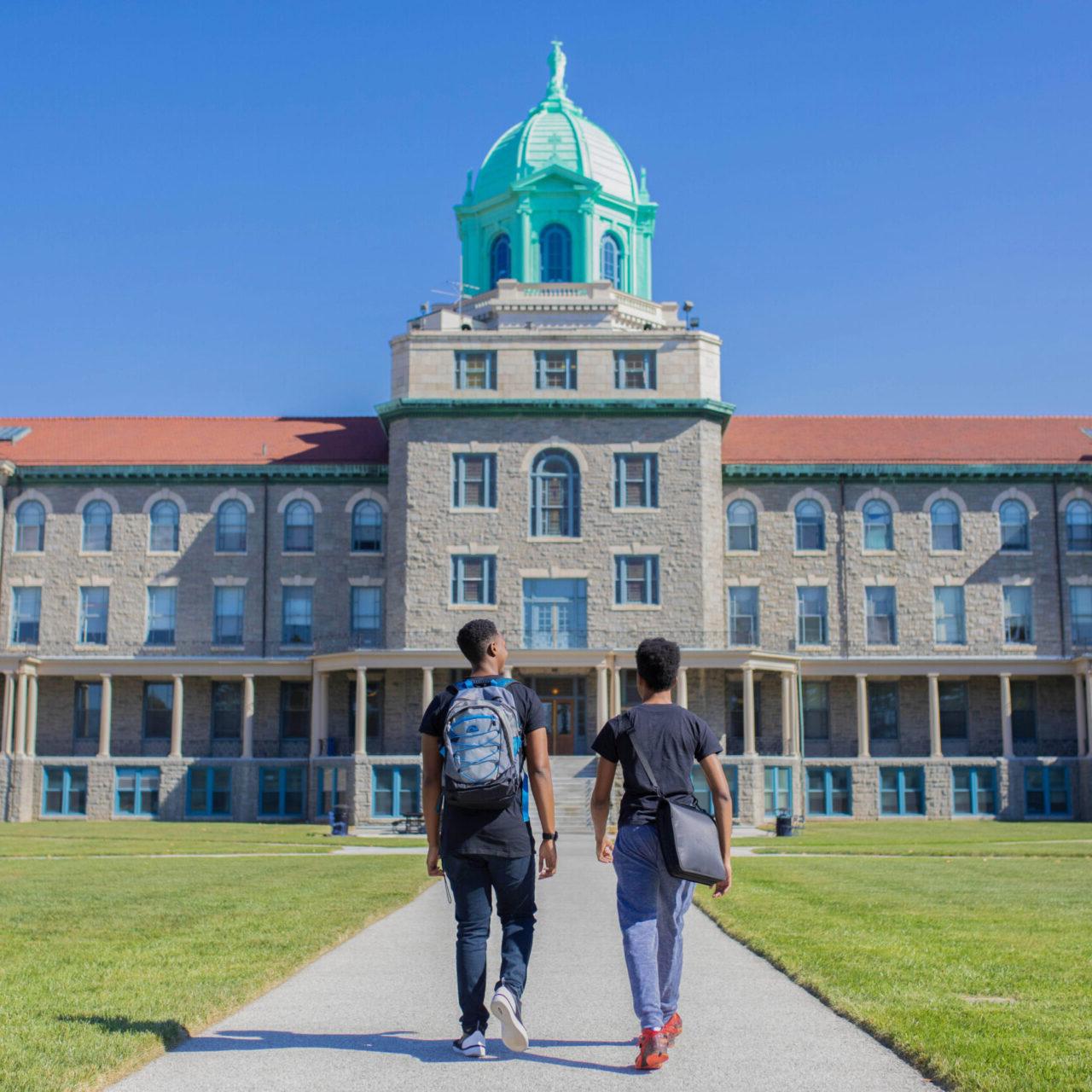 两个学生走在大学大楼前
